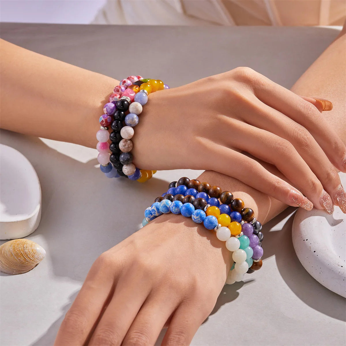 Colorful natural stone charm bracelets stacked on wrist