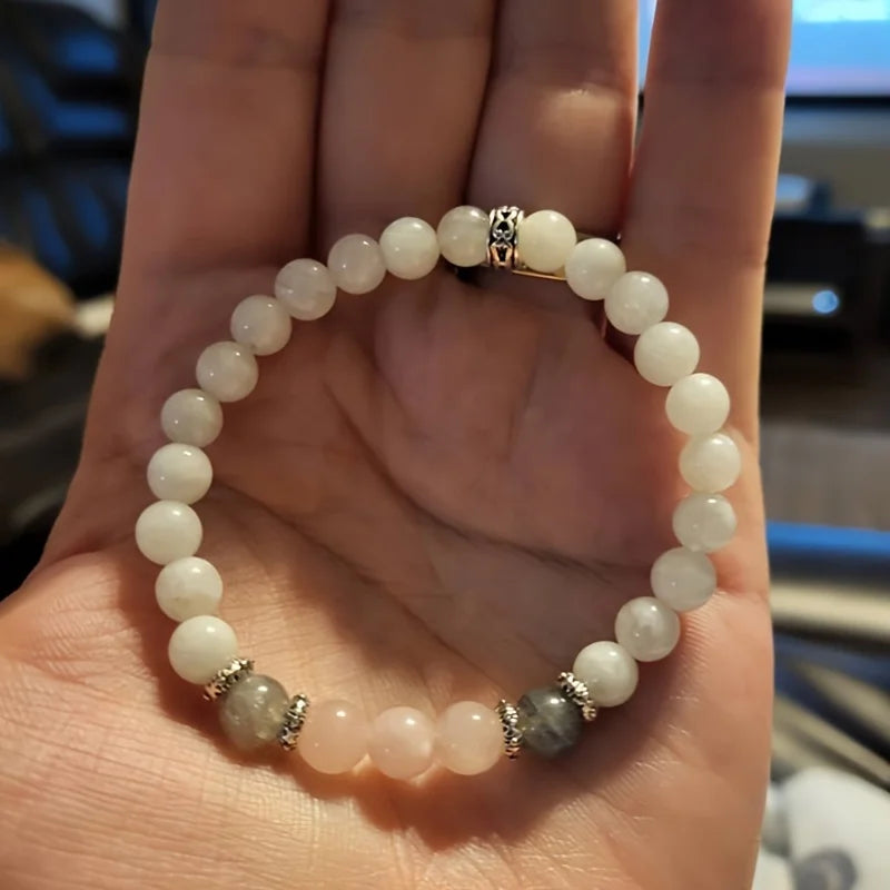 Flat-lay of natural crystal bracelet featuring labradorite, moonstone, and rose quartz stones