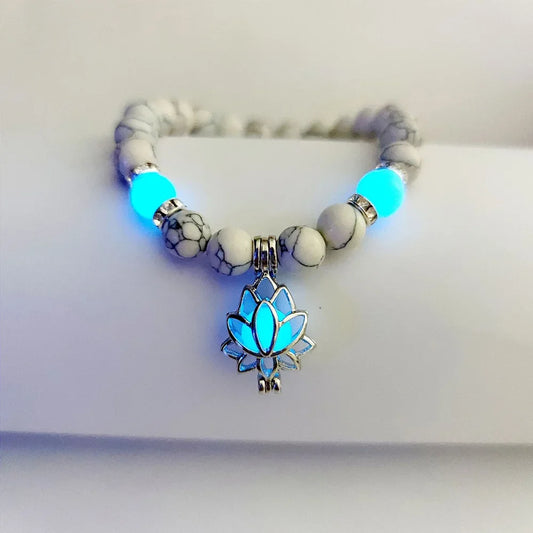 Glow-in-the-dark bracelet with lotus charm glowing in low light