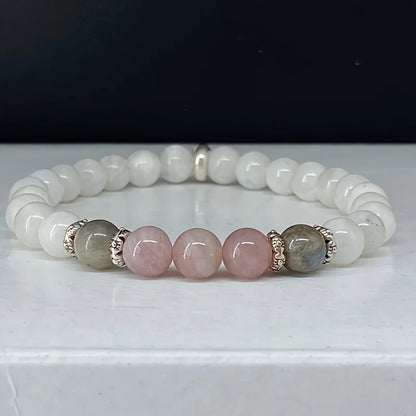 Mystic Moon Trio Bracelet with labradorite, moonstone, and rose quartz beads on a neutral background